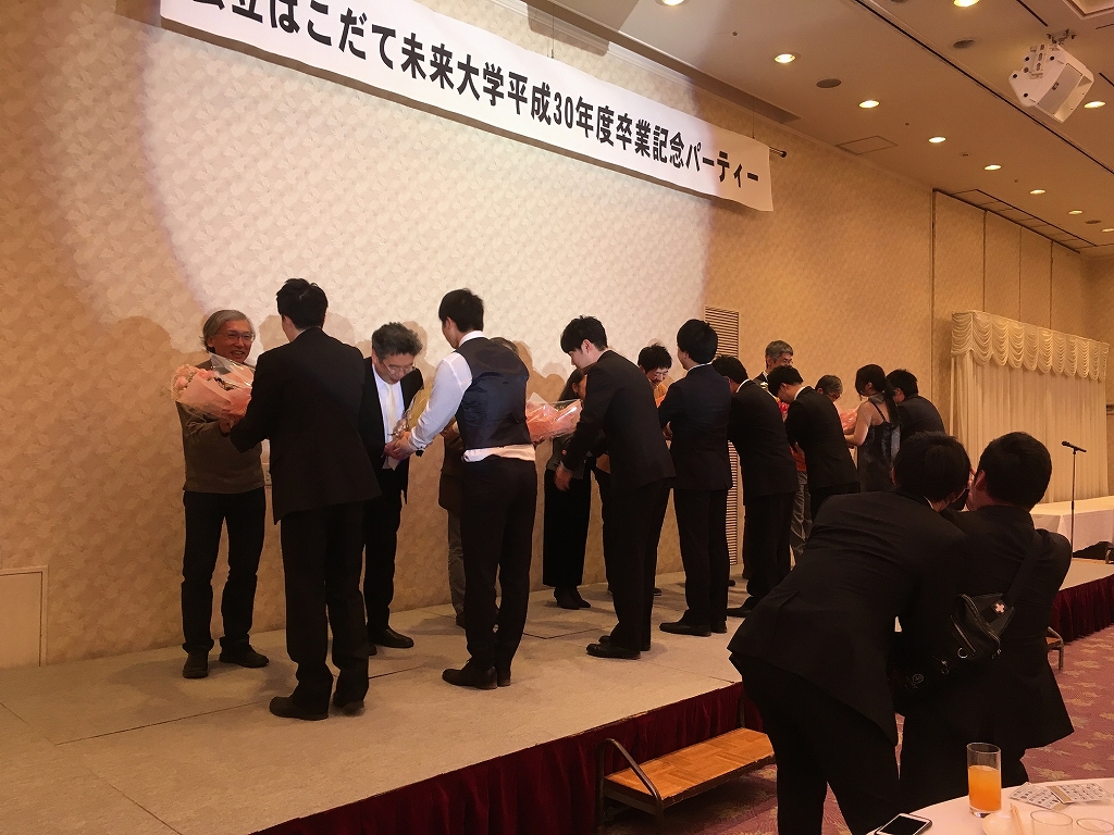 ステージ上で花束を贈呈される先生