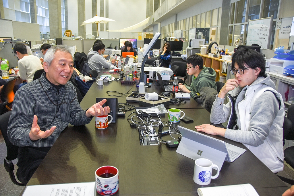 開放的な空間で学生と議論する平田教授